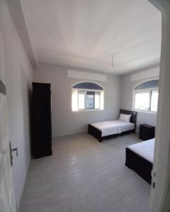 una camera con due letti e due finestre di Appartement avec grande terrasse NEYLA Del Mar Inn Tanger a Tangeri