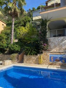 uma piscina em frente a uma casa em The 3 Singing Palms em Lloret de Mar