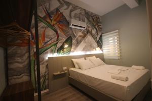 a room with a bed with a painting on the wall at Alyvia Rooms in Himare