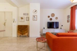 a living room with a orange couch and a tv at Sonnino House in Cagliari