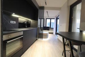 a kitchen with black cabinets and a table in it at Skyline Suite&Spa in Thessaloniki