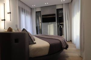 a bedroom with a bed in a room with windows at Skyline Suite&Spa in Thessaloniki