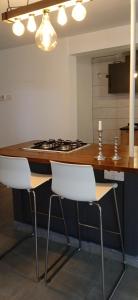 a kitchen with two white chairs and a counter at Large basement home in Kolossi
