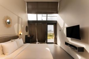 ein Hotelzimmer mit Bett und Fernseher in der Unterkunft Beyond by Sula in Nashik