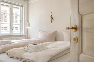 two beds in a white room with towels on them at Luettje Huus in Flensburg
