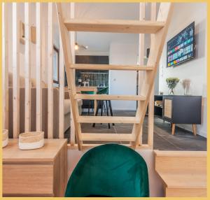 sala de estar con escaleras de madera y silla verde en Appartement T2 Unique Cluses en Cluses