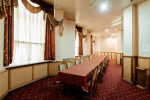 una sala de conferencias con una mesa larga y sillas en Dacia Hotel, en Chişinău