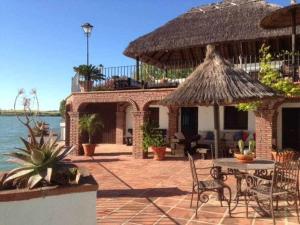 un patio con mesa y sillas y un edificio en Espectacular casa con embarcadero, en Arcos de la Frontera