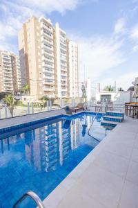 ein großer Pool mit Gebäuden im Hintergrund in der Unterkunft Itanhaém Praia & Mar in Itanhaém