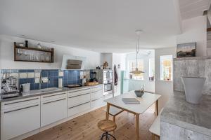 a kitchen with white cabinets and a table in it at Luettje Huus in Flensburg