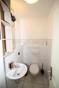 a white bathroom with a toilet and a sink at Ferienwohnung Sonnen See in Ascheberg