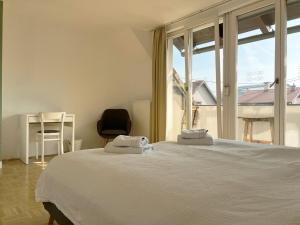 een slaapkamer met een bed en een groot raam bij HoMEMADE Bed and breakfast in Ljubljana