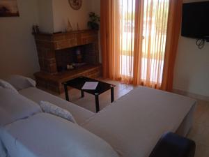 a living room with a couch and a fireplace at Mary's House in Vourvourou