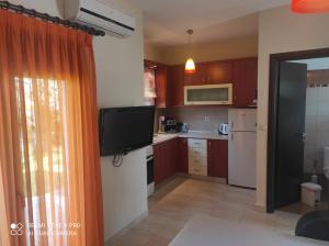 a kitchen with a flat screen tv in a room at Mary's House in Vourvourou