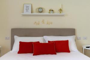 a bedroom with a bed with red pillows at Sonnino House in Cagliari