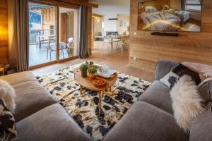 a living room with a couch and a table at Chalet Mevi - OVO Network in Crest-Voland