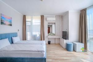 a hotel room with a bed and a tv at Aparthotel Royal Marina Beach in Chernomorets