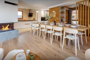 a dining room with a table and chairs and a fireplace at Chalet Mevi - OVO Network in Crest-Voland
