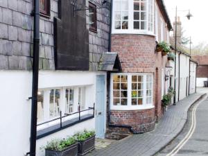 a brick building with a blue door on a street at Characterful apartment in the heart of Petworth in Petworth