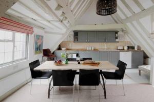 a kitchen with a table and chairs in a room at Characterful apartment in the heart of Petworth in Petworth