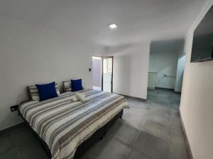 ein Schlafzimmer mit einem großen Bett mit blauen Kissen in der Unterkunft East Park Inn in Polokwane