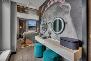 a hotel room with a bed and a mirror at Roomzzz Edinburgh in Edinburgh