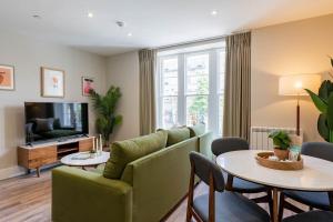 a living room with a couch and a table at Wellington Place I Your Apartment in Bristol