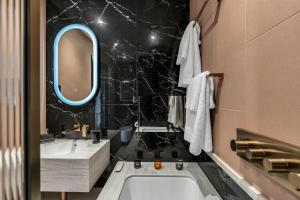 a bathroom with a tub and a sink and a mirror at Roomzzz Edinburgh in Edinburgh