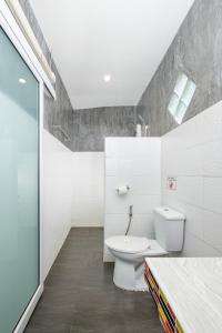 ein weißes Bad mit einem WC und einem Waschbecken in der Unterkunft All At Sea Beach Resort in Baan Tai