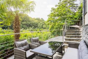 um pátio com uma mesa, cadeiras e escadas em Casa Magging un oasi nel verde em Locarno