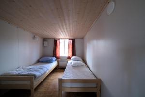 two beds in a small room with a window at Pukinsaaren Camping in Kristiinankaupunki