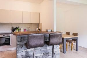 cocina con encimera, mesa y sillas en Casa Magging un oasi nel verde en Locarno