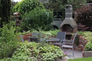 un jardin avec une table, des chaises et des plantes dans l'établissement Ferienwohnung Lorenz´ Traumzeit - Emsland, à Dörpen