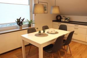 a kitchen with a table and chairs in a kitchen at Ferienwohnung Lorenz´ Traumzeit - Emsland in Dörpen
