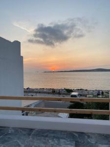 a view of a beach with the sun setting over the water at Lyra Sunset Suite in Kampos Paros