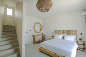 a white bedroom with a bed and a staircase at Lyra Sunset Suite in Kampos Paros
