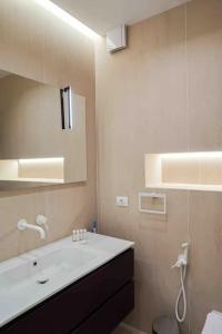 y baño con lavabo blanco y espejo. en Studio modern în centrul Constantei, en Constanţa