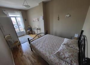 a bedroom with a bed with a floral bedspread at Les 5 balcons in Le Tréport