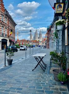 una panchina in una strada in una città con edifici di Les chambres atypiques de Nico Bush - Parking sécurisé vélos a Tournai