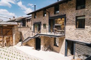 a brick house with a balcony and a bike on the side at Mas Cal Rus in Alp