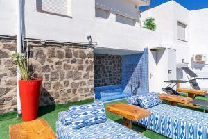 a patio with blue and white furniture and a building at Apartamentos Dulcemar Frente al Mar con zona SPA in San José