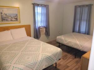 a small bedroom with two beds and a window at Surf Villa Hotel in Ocean City