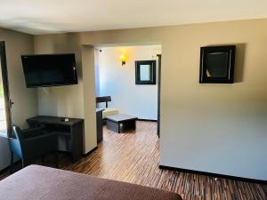 a hotel room with a large door leading to a living room at L'HOTEL DE LA BOURSE à BAGNOLS-SUR-CEZE in Bagnols-sur-Cèze