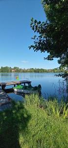 a boat parked next to a dock on a lake at Dom na Mazurach Jeziorna in Miłki