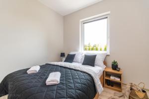 a bedroom with a large bed and a window at Flatbook Apartamenty - Mikoszewo Dudówka in Mikoszewo