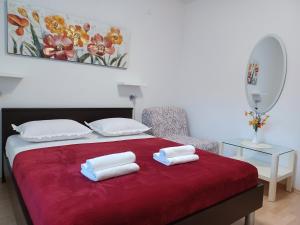 a bedroom with a bed with two towels on it at MG Ravlic Apartments in Makarska