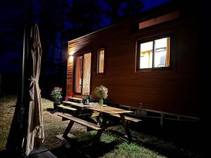 a picnic table in front of a tiny house at Tiny House et chevaux in Le Breuil
