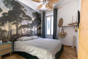 a bedroom with a bed with a painting on the wall at Appart Port Cassis Village Parking in Cassis
