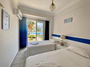 a hotel room with two beds and a window at Korfez Life Apartments in Fethiye