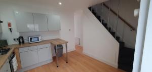 a kitchen with white cabinets and a counter with a microwave at Roomy dog friendly Gosport town house sleeps 6 in Gosport